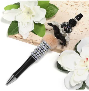 Close-up detail of a handmade DIY beaded ballpoint pen decorated with pearls, rhinestones and plush.