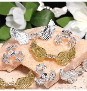 Gros plan sur les ailes d'ange en strass et capuchons de perles en alliage bijoux DIY.