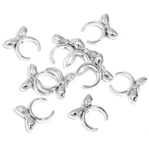 Primo piano di copriperline ad anello aperto con fiocco argento, accessori per gioielli.