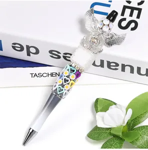 Stylo à bille DIY exquis avec ailes d'ange en strass et pendentifs cœurs colorés.