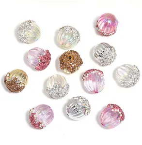 Detailed view of DIY acrylic rhinestone pumpkin beads and pinecone charms for handmade accessories.