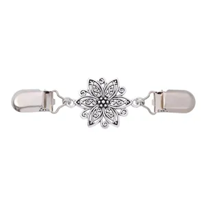Primo piano dettagliato di clip per maglione vintage argento con intaglio floreale.