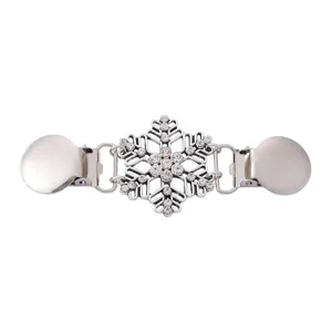 Dettaglio ravvicinato della clip per maglione con fiocco di neve in strass argento.