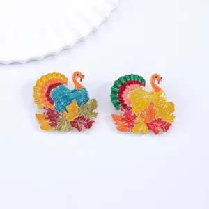 Close-up of colorful autumn turkey enamel brooches with maple leaf details, charming accessories.