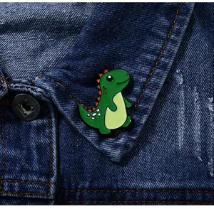 Jolie broche émaillée en forme de petit dinosaure vert pour veste et sac à dos.