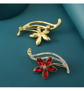 Nahaufnahme Detail der roten Kristall Blumen Brosche, zeigt glitzernde Steine und Metallnadel.