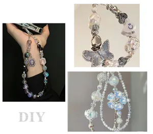 Detailed view of DIY handmade beaded phone charm with butterfly and flower pendants and pearls.