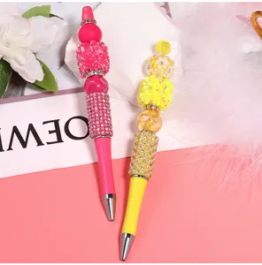 DIY beaded ballpoint pens with colorful resin rhinestones and shiny decorative beads for crafting.
