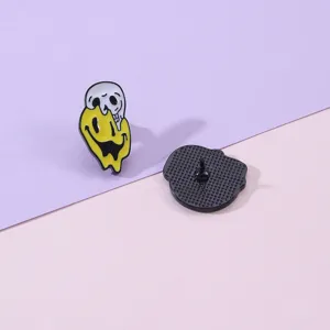 Close-up detail of creative melting smiley skull alloy brooch pin front and back view.