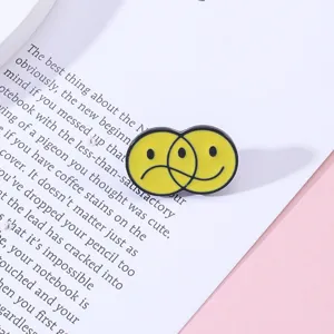 Cartoon alloy enamel pin brooch with funny overlapping smiley and sad faces for bags clothes.