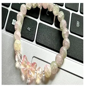 Close-up detail of a handmade DIY crystal glass beaded bracelet featuring a cute pink bow.