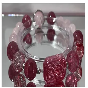 Vista detallada de pulsera de cuentas de vidrio coloridas con placa de flor cuadrada.