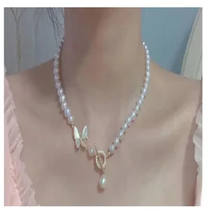 Zoete parelketting met vlinderhanger en metalen sluiting detailweergave voor dames.