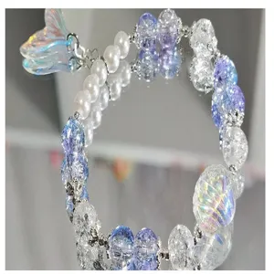 DIY beaded bracelet with purple glass beads white pearls and iridescent mermaid tail pendant