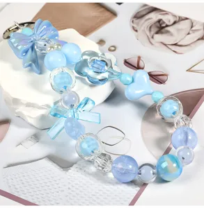 Blue acrylic beaded phone charm DIY detail shot with cute bows, hearts, and transparent beads.