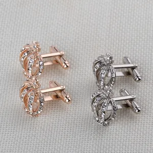 Vue détaillée de boutons de manchette couronne en métal avec strass étincelants en argent.
