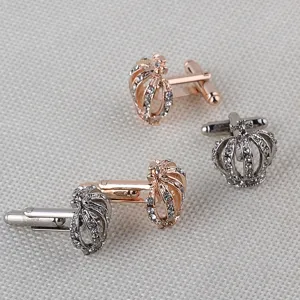 Gros plan détail des boutons de manchette strass couronne luxe, texture métal et finition soignée.