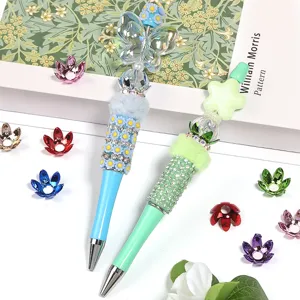 DIY beaded pens set with colorful acrylic flower caps and rhinestone charms for handmade craft jewelry.