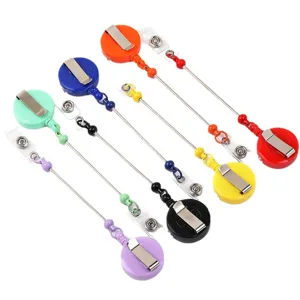 Porte-badge rétractable multicolore avec cordon perlé et clip métallique pour cartes d'ID.