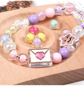 Nahaufnahme bunter transparenter Acrylperlen und süßer Sternanhänger für kreative DIY Handyketten.