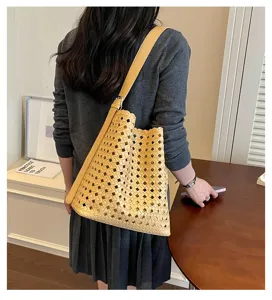 Vue détaillée d'un sac cabas en cuir ajouré élégant porté à l'épaule, style quotidien décontracté.