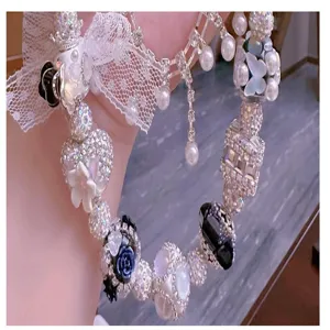 Detailansicht des DIY Strassperlen Armbands mit glitzernden Anhängern und feiner Spitzenverzierung.