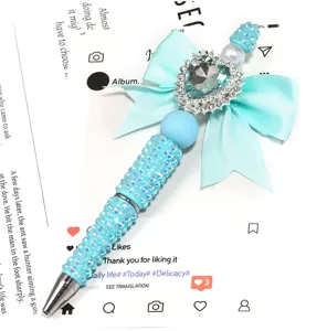 Stylo à bille perlé en strass bleu clair fait main avec nœud et pendentif cœur pour cadeaux.