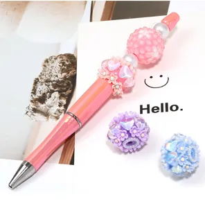 Dettaglio della penna a sfera di perle fai da te con perline di fiori scintillanti e corpo rosa.
