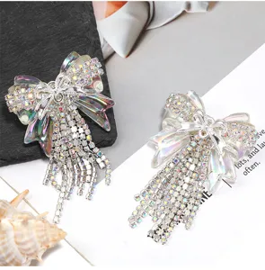 Close-up of sparkling rhinestone bow pendant with shimmering iridescent crystal fringe chains.