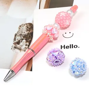 Penna a sfera di perline fai da te con sfere di strass rosa e ciondoli floreali a cuore.
