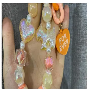 Chaîne de téléphone en perles DIY avec cœurs irisés, breloques de chien et accessoires.