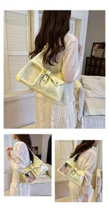 Stylish yellow patent leather shoulder bag with transparent pocket for casual looks.