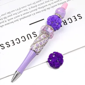 Stylo à billes DIY avec perles de roses violettes et strass, papeterie artisanale créative.