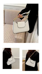 Vue détaillée du sac à épaule blanc élégant avec motif gaufré et chaîne dorée raffinée.