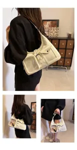 Detail view of the white patent leather shoulder bag with transparent front pocket and belt.