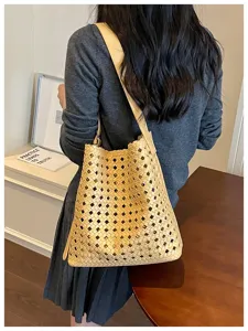 Sac cabas en cuir souple tressé pour femme, grand sac seau porté épaule, style chic et décontracté.