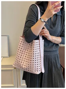 Sac cabas en cuir tressé rose pour femme, grand sac seau élégant porté épaule chic.