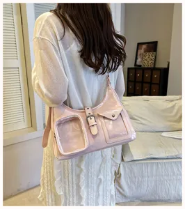 Pink glossy shoulder bag with clear front pocket detail, stylish niche design everyday wear.