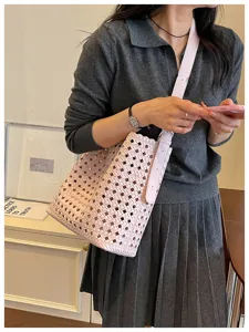 Vue détaillée du sac seau tissé rose, élégant sac à bandoulière en cuir souple pour femme.