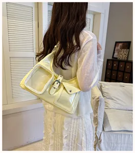 Yellow patent leather crossbody bag with clear window pocket, casual street fashion style detail.