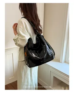 Detailed view of black shiny PU leather hobo backpack bag in minimalist indoor scene style.