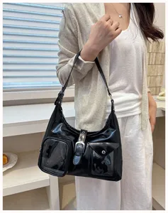 Black glossy shoulder bag detail, featuring front utility pockets and metal buckle.