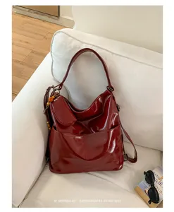 Red PU leather convertible shoulder bag and backpack with front pocket and chic charm decor.