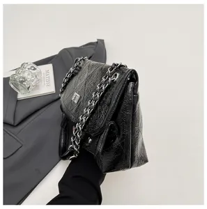 Nahaufnahme der schwarzen Knautschleder Schultertasche mit Metallkette und Drehverschluss.