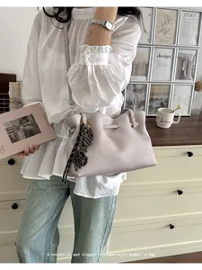 Vista dettagliata della borsa tote vintage da donna con texture elegante e ciondolo chic.