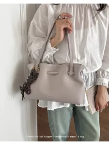 Vista dettagliata della borsa tote elegante in pelle da donna con tracolla vintage e ciondolo.