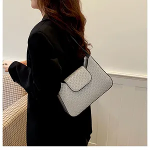 Vue détaillée d'un sac à épaule minimaliste élégant avec une texture tissée chic et rabat.