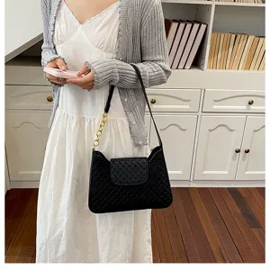 Élégante sacoche noire d'épaule avec chaîne dorée et rabat texturé pour un style chic.