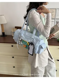 Detailed view of light blue Japanese-style shoulder pain bag with clear window and charms.