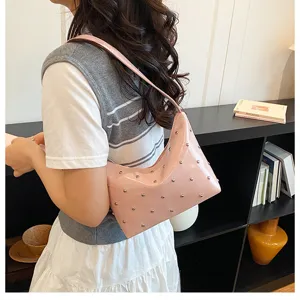 Pink patent leather shoulder bag with chic metal studs, stylish hobo armpit bag for daily wear.